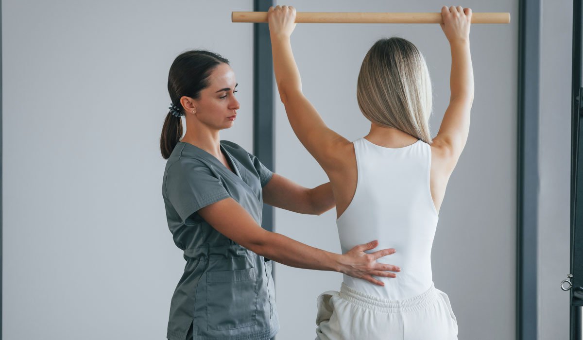 Person performing exercise rehabilitation under the guidance of a physical therapist.